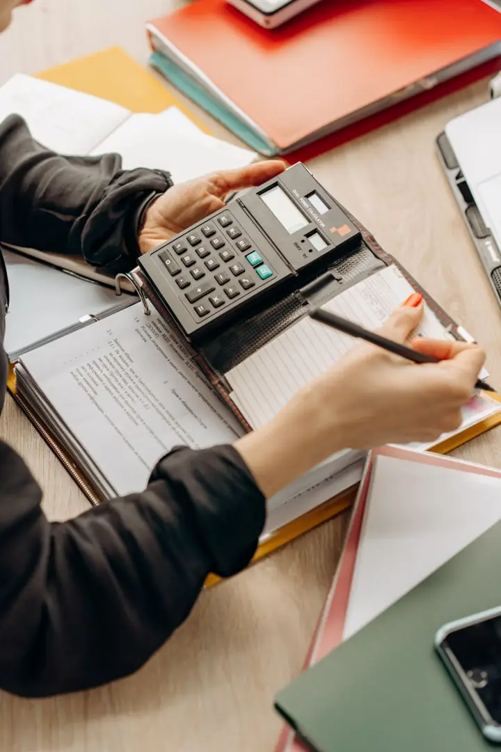 Payroll figures being checked with a calculator